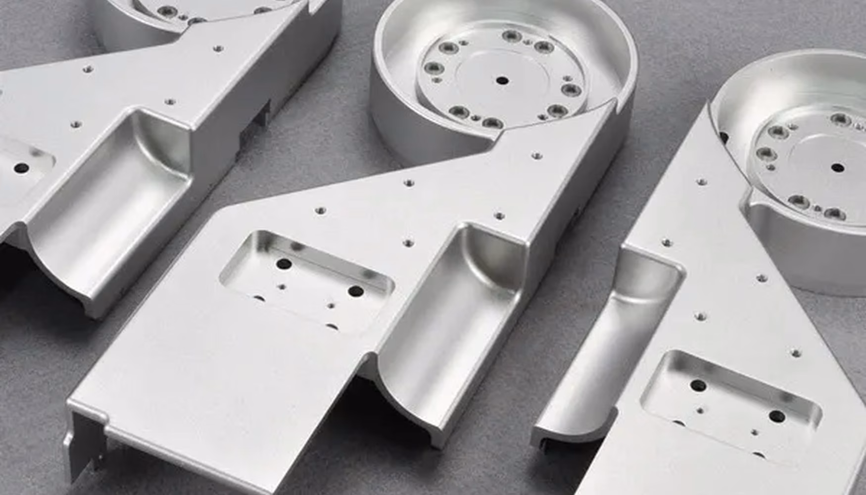 Three machined aluminum product-development housings arranged as a prototype set